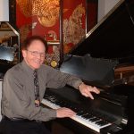 PIANIST DENNIS CHANDLER SEATED AT HIS SOHMER